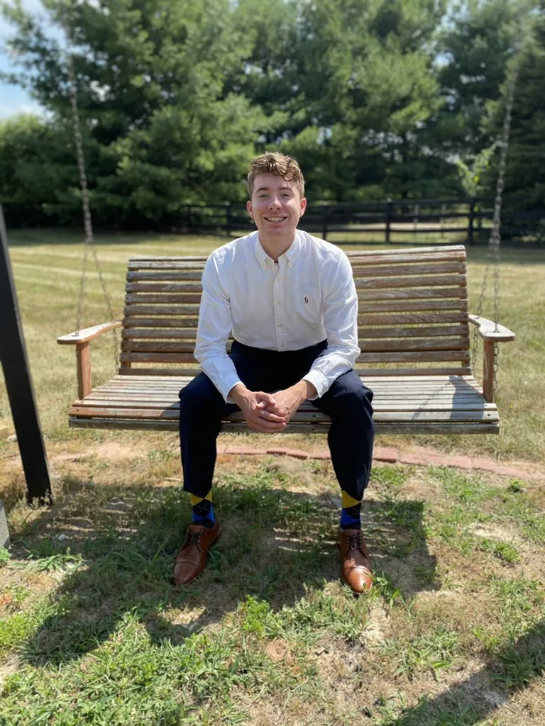 Riley Nodland seated on a wooden bench outdoors